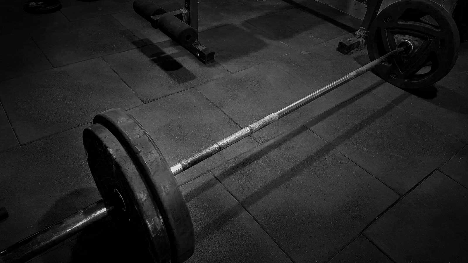 Deadlift barbell with 75 kg weight on a gym floor